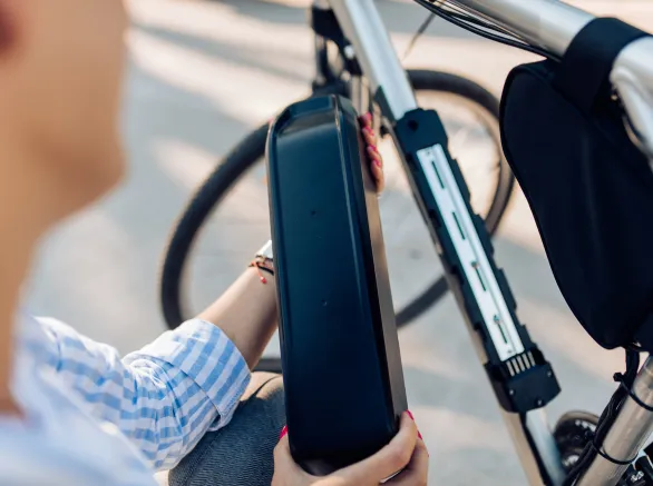 Mid adult woman charging her electric bicycle on her way to work.